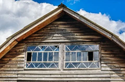 Gable End of an Aged Cottage with Horizontal Wooden Siding and Windows Stock Photos