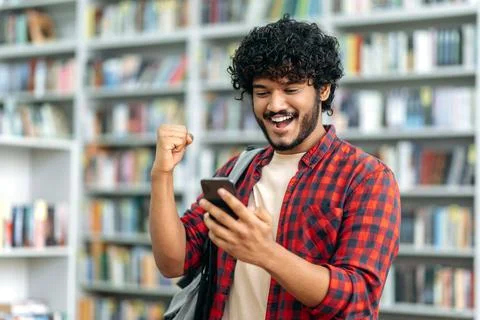 Gadgets concept, wireless technology. Cheerful indian or arabian guy, freelancer Stock Photos