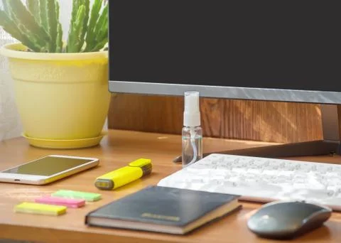 Gadgets, a white computer keyboard and stationery next to a hand sanitizer an Stock Photos
