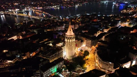 Galata Tower at night, surrounded by city lights 動画素材 302470612