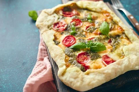 Galette-type pie made from puff pastry and filled with tomatoes, mozzarella.. Stock Photos