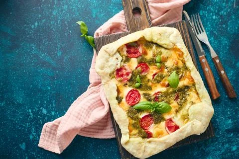 Galette-type pie made from puff pastry and filled with tomatoes, mozzarella.. Stock Photos