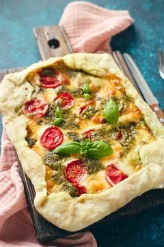 Galette-type pie made from puff pastry and filled with tomatoes, mozzarella c 写真素材