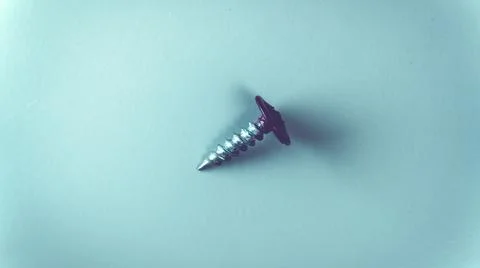 Galvanized self-tapping screw with painted head on a gray background. Stock Photos