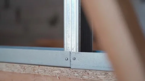 Galvanized U profile for plasterboard frame wall. Metal profile connection close Stock Footage 238724203