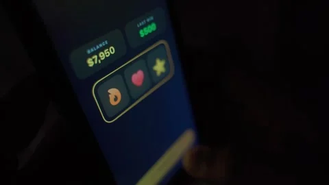 Gambling addict playing slots on smartphone in the dark. Wins and jackpots on Stock Footage 341746232