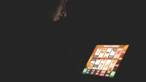 Gambling addicted man with glasses in front of online casino slot machine Vidéo 82123917