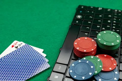 Gambling chips on computer keyboard on green background Stock Photos