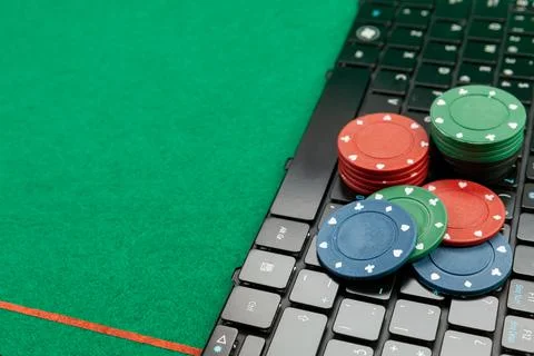 Gambling chips on computer keyboard on green background Stock Photos