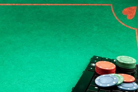 Gambling chips on computer keyboard on green background Stock Photos