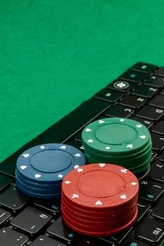 Gambling chips on computer keyboard on green background Stock Photos