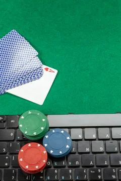 Gambling chips on computer keyboard on green background Stock Photos