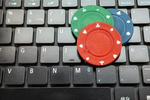 Gambling chips on computer keyboard on green background Stock Photos