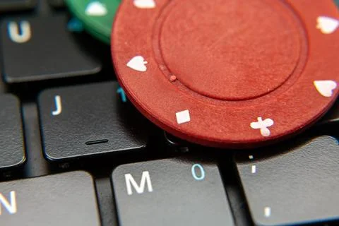 Gambling chips on computer keyboard on green background Stock Photos