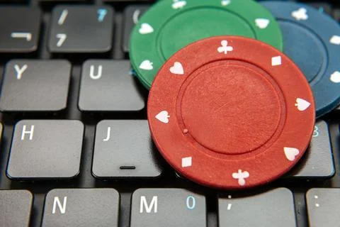 Gambling chips on computer keyboard on green background Stock Photos