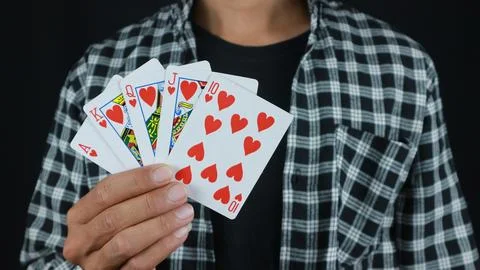 Gambling concept. Close up of Poker Player male hand Winning Royal Flush , .. Stock Photos