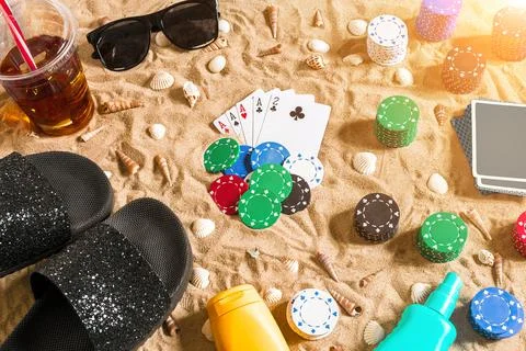 Gambling on vacation concept - white sand with seashells , colored poker chips Stock Photos