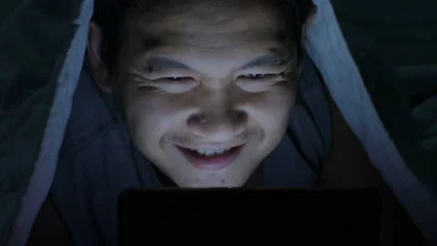 Game addicted, man playing online game on his smart phone while lying on bed  Video stock 142040140