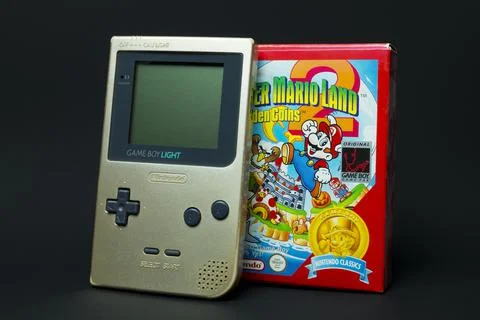 Game Boy Light console and Super Mario Land game box. Stock Photos