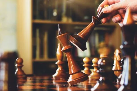 Game of chess. The guy makes a move. Checkmate. Wooden chess pieces. Strategy Stock Photos