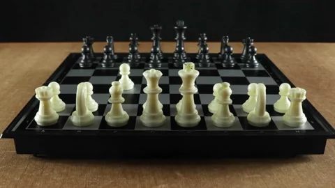 A game of chess. A man plays with himself moving pieces on a black chessboard Stock Footage 145385659