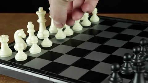 A game of chess. A man's hand moves a chess piece on a blackboard. Stock Footage 145385600