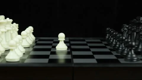 A game of chess. A man's hand moves a pawn on the black chessboard. Stock Footage 145385643