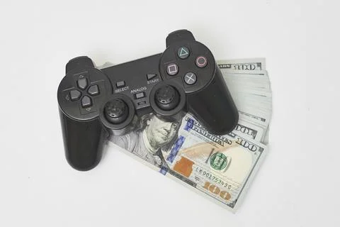 Game console controller and pile of money Stock Photos