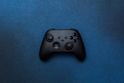 Game controller on a blue background. Black joystick for computer games top v Stock Photos