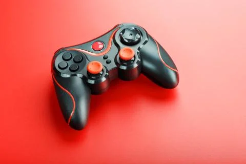 Game controller controller on red background. Device to control and control t Stock Photos