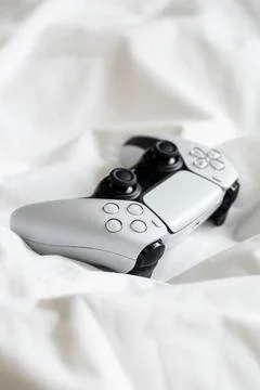Game controller, lying on white sheets of bed at home. Foto stock