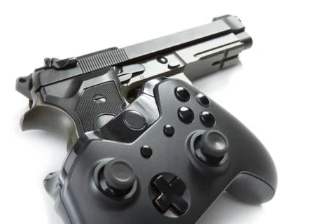 Game controller over a real handgun - close up studio shot. Virtual and real  Fotos de archivo
