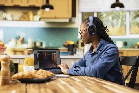 Game developer on laptop multitasking with visual effects and listening to music Stock Photos
