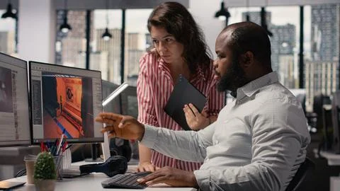 Game developers working on futuristic video game on computer Stock Photos