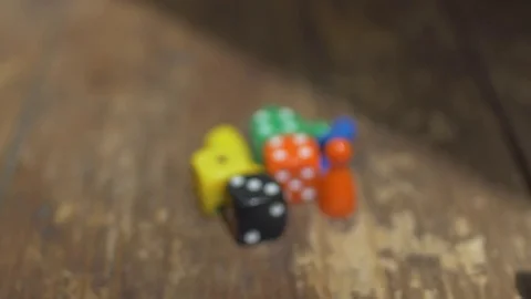 Game dice and counters on wooden table Stock Footage 70687948