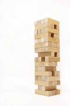 A game of logic and the ability to think. Jenga tower with wooden blocks on a Stock Photos