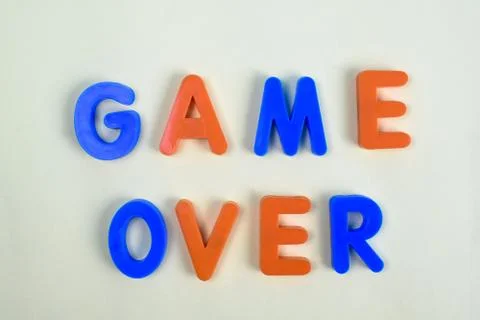 GAME OVER written in various colored letter blocks on a white background Stock Photos