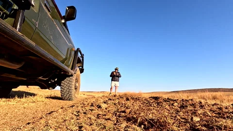 Game ranger explains to guests on safari truck what elephant dung looks like Vídeo Stock 316245443