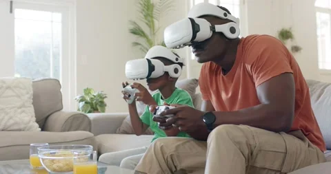 As game is starting, father and son are leaning on sofa holding controllers, Stock Footage 340612723