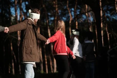 The game is a team work where blindfolded people walk through the woods holdi Stock Photos
