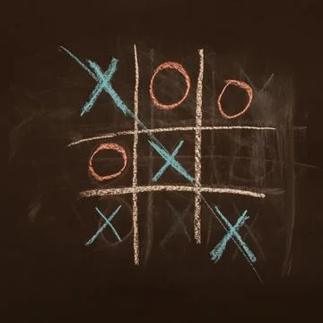 Game tic-tac-toe drawn with chalk on a black board, victory. Stock Photos