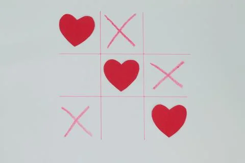 Game tic-tac-toe. Elements in the form of a red heart. Stock Photos