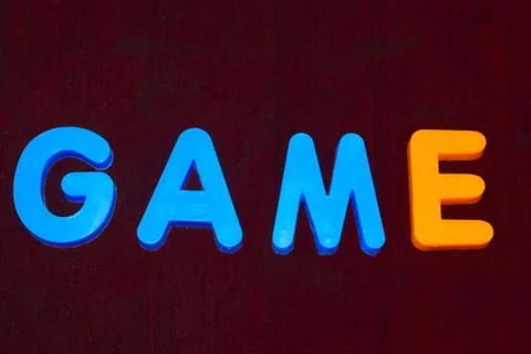 Game word written with different colored letter blocks on a dark background Stock Photos