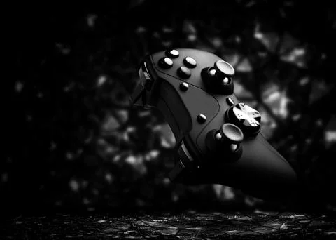 The gamepad is black on a dark background. Stock Photos