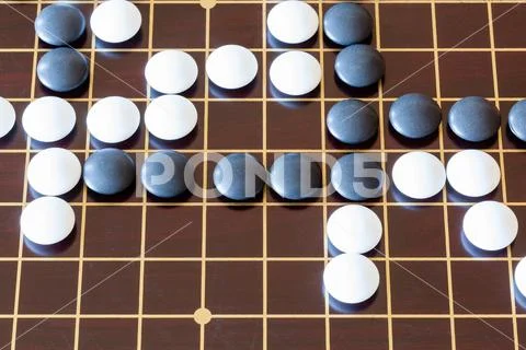 Gameplay of Go game on wooden board Stock Photos