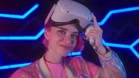 Gamer adjusting VR headset in a neon-lit room. Stock Footage 260821165