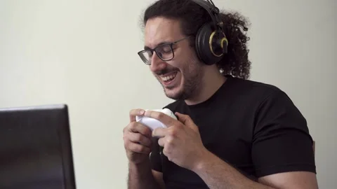 Gamer with computer laptop laughs while playing Stock Footage 290954084