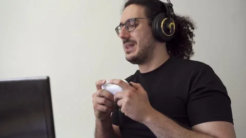 Gamer with computer laptop talks with his friends while playing Stock Footage 290954085