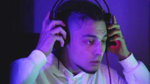 Gamer guy removes headset with microphone from head Vidéo 144369370