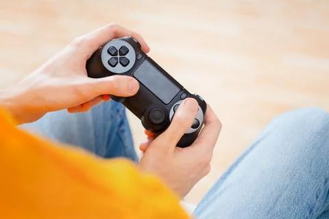 Gamer Holding Controller in Bright Orange Sweatshirt Stock Photos